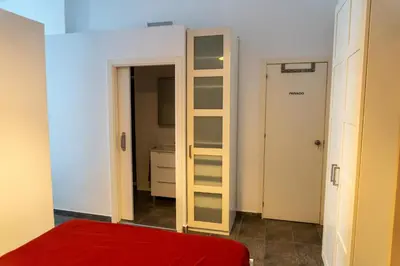 a bedroom with a red bed and a closet at Full 50sqm Loft in Badalona in Badalona