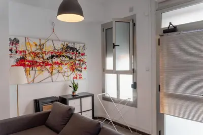 a living room with a couch and a painting on the wall at Full 50sqm Loft in Badalona in Badalona