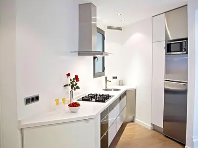 a white kitchen with a stove and a refrigerator at Flat with views to Sagrada Famila in Barcelona