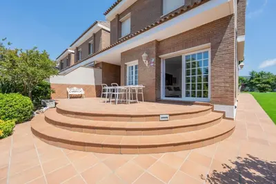 a patio with a table and chairs in front of a house at Casa Nina junto Barcelona Centro y playa in Teià