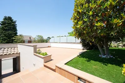 a small garden with a tree on a patio at Casa Nina junto Barcelona Centro y playa in Teià
