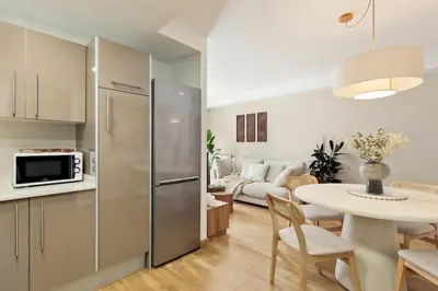 a kitchen and living room with a refrigerator and a table at Cerca de la Playa y El Born, con Piscina in Barcelona