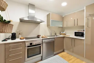 a kitchen with stainless steel appliances and a sink at Cerca de la Playa y El Born, con Piscina in Barcelona