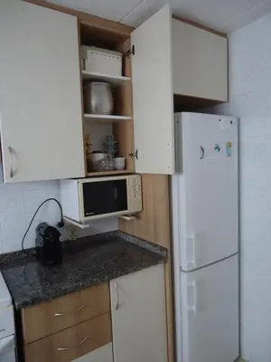 a kitchen with a white refrigerator and a microwave at brisa mar in San Pol de Mar
