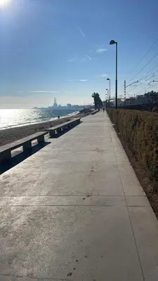 a sidewalk next to a beach with the ocean at Apartamento de una habitación con terraza grande cerca de Barcelona in Badalona