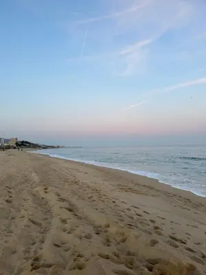 a beach with footprints in the sand and the ocean at Apartamento de una habitación con terraza grande cerca de Barcelona in Badalona