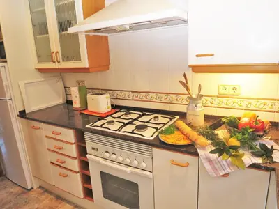 a kitchen with a stove and a plate of food at Carmen Seaview & Beach - Apartment in Montgat