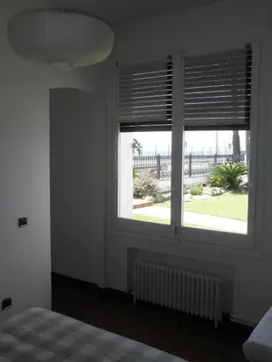 a bedroom with a window with blinds and a bed at Apartament Can Batlle in Premiá de Mar