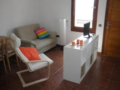 a living room with a couch and a tv and a chair at Apartament Can Batlle in Premiá de Mar