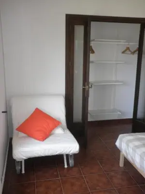 a room with a couch with a red pillow on it at Apartament Can Batlle in Premiá de Mar