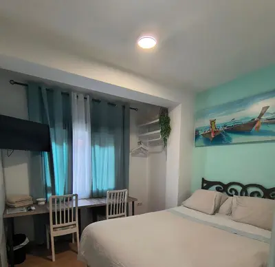 a bedroom with a bed and a desk and a television at BARCELONA AIRPORT Mi COLIBRÍ in El Prat de Llobregat