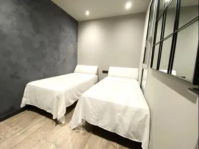two beds in a room with white sheets on them at Gaudi Comfort in Barcelona