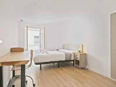 a bedroom with a bed and a desk and a window at Apartamento exclusivo a 15 min de Barcelona in Sant Cugat del Vallès