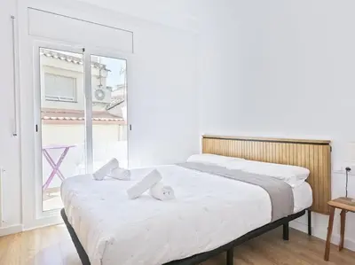 two beds in a white room with a window at Apartamento exclusivo a 15 min de Barcelona in Sant Cugat del Vallès