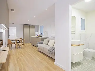 a living room and kitchen with a couch and a table at Apartamento exclusivo a 15 min de Barcelona in Sant Cugat del Vallès