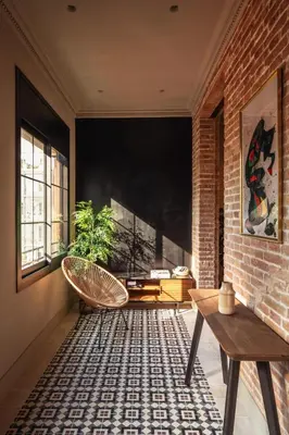 a room with a brick wall and a bench and a table at Lovely 6 BR Flat in L'Eixample in Barcelona