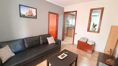 a living room with a black leather couch and a table at My best house BCN in Barcelona