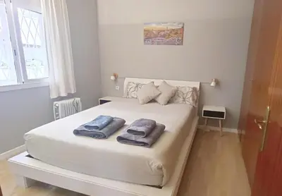a bedroom with a white bed with towels on it at My best house BCN in Barcelona