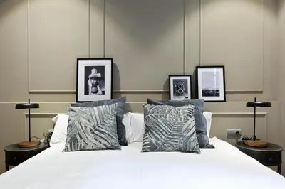 a bedroom with a white bed with three pictures on the wall at Sagrada266 by chicStays in Barcelona