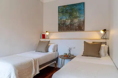 a bedroom with two beds and a painting on the wall at Canela Homes BARCELONA BRUC in Barcelona