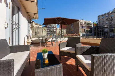 a patio with chairs and an umbrella and a table at Charming Central Apartment Big Sunny Terrace! in Barcelona