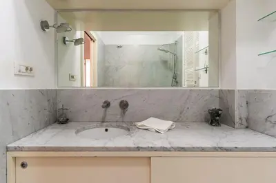 a bathroom counter with a sink and a mirror at Canela Homes BARCELONA LIGHT in Barcelona