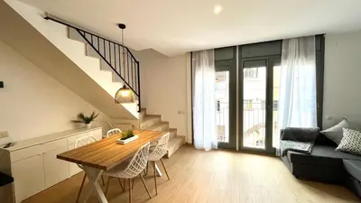 a kitchen and living room with a table and a couch at Dúplex 2 hab con terraza by Prestigi in Terrassa