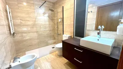 a bathroom with a sink and a toilet and a mirror at Dúplex 2 hab con terraza by Prestigi in Terrassa