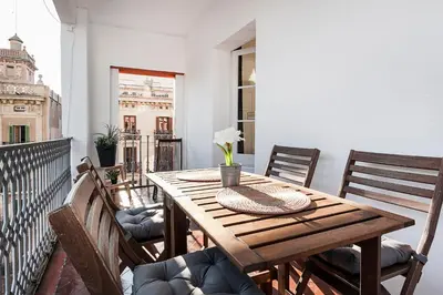 a wooden table on a balcony with chairs at Beautiful apartment with terrace in Barcelona in Barcelona