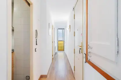 a hallway of a house with white walls and a wooden floor at Avenida Gaudí View 2-Min to Sagrada in Barcelona