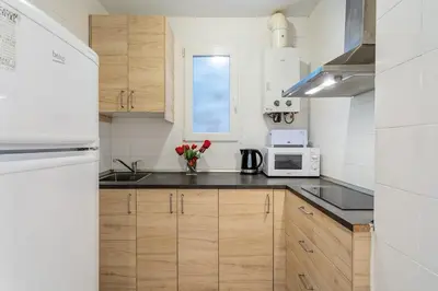 a kitchen with wooden cabinets and a white microwave at Avenida Gaudí View 2-Min to Sagrada in Barcelona