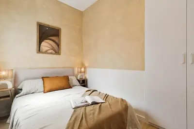 a living room with a couch and a table with a chair at Pontone - 2 bedrooms and balcony in Eixample Dreta in Barcelona