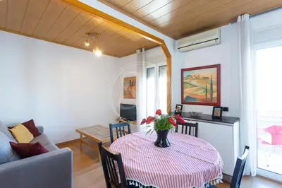 a living room with a table with a vase of flowers on it at Bonito alojamiento cerca de Plaza España in Barcelona