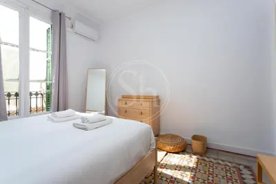 a dining room with a table and chairs and windows at Modern flat near Sagrada Familia in Barcelona