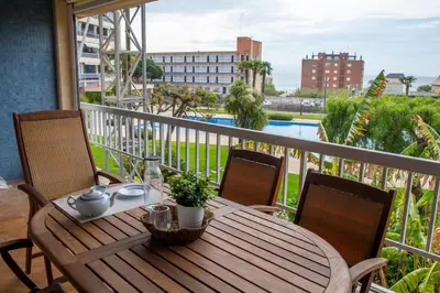 a wooden table and chairs on a balcony at Apartment of 100m2 with sea views in Sant Vicenç de Montalt