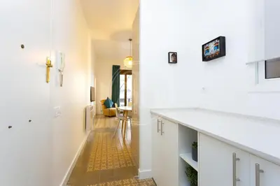 a hallway with white walls and a yellow tile floor at Apartamento cerca de Sagrada Familia in Barcelona