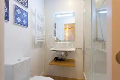 a white bathroom with a sink and a shower at Apartamento cerca de Sagrada Familia in Barcelona