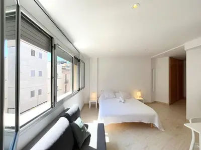 a bedroom with a bed and a large window at M2 Apartament cèntric in Terrassa