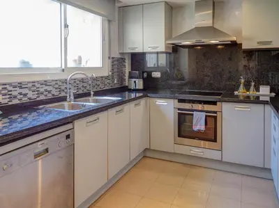 a kitchen with white cabinets and a sink at La Perla by Hello Homes Sitges in Sitges