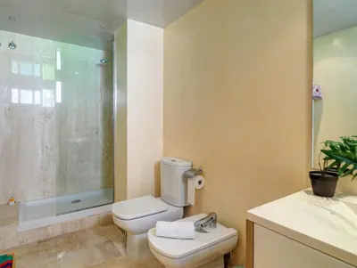 a bathroom with a toilet and a shower and a sink at La Perla by Hello Homes Sitges in Sitges