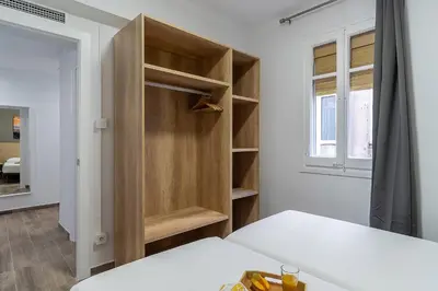 a bedroom with a bed and a wooden closet at 4213 - AB Sagrada Familia Views VI-I in Barcelona