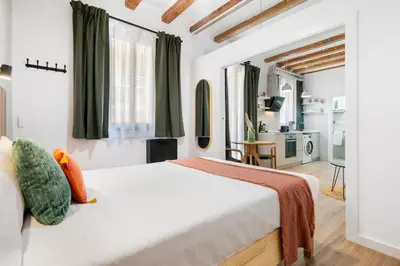 a bedroom with a large white bed and green curtains at Lodging Apartments Almirall Beach 31 in Barcelona