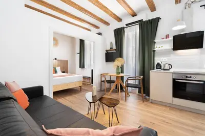 a living room with a couch and a dining room at Lodging Apartments Almirall Beach 31 in Barcelona