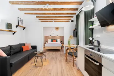 a living room with a couch and a bed at Lodging Apartments Almirall Beach 31 in Barcelona