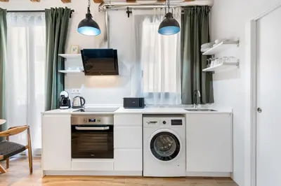 a kitchen with a washing machine and a sink at Lodging Apartments Almirall Beach 21 in Barcelona