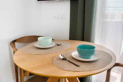 a wooden table with two cups and saucers on it at Lodging Apartments Almirall Beach 21 in Barcelona
