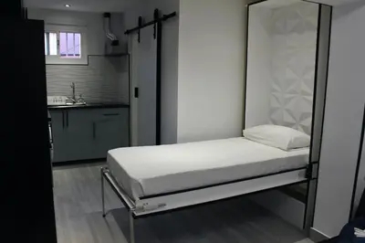 a bed in a small room with a kitchen at Work Stay in Gavà