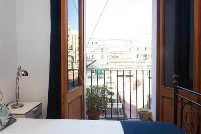 a bedroom with a view of a city from a balcony at Tranquilo y luminoso apartamento en el Eixample in Barcelona
