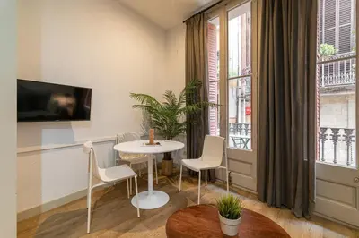 a living room with a table and chairs and a window at Stay U-nique Apartment Boters in Barcelona