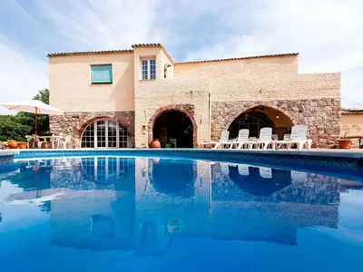 a house with a swimming pool in front of a building at Holiday Home Can Trullas by Interhome in Viladecaballs
